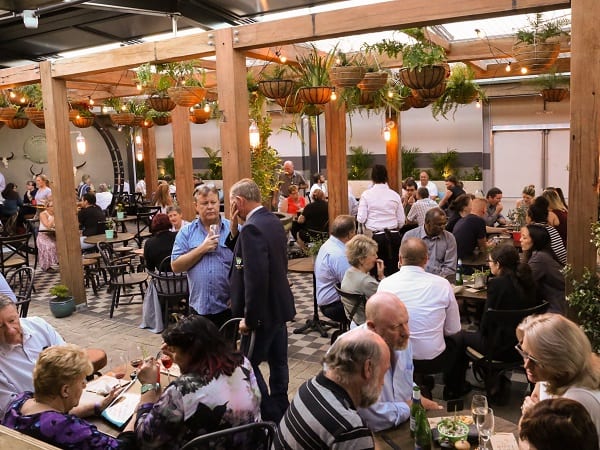 photograph of busy beer garden at dusk with guests