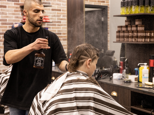 photo of Kingsmen Hair barber spraying water