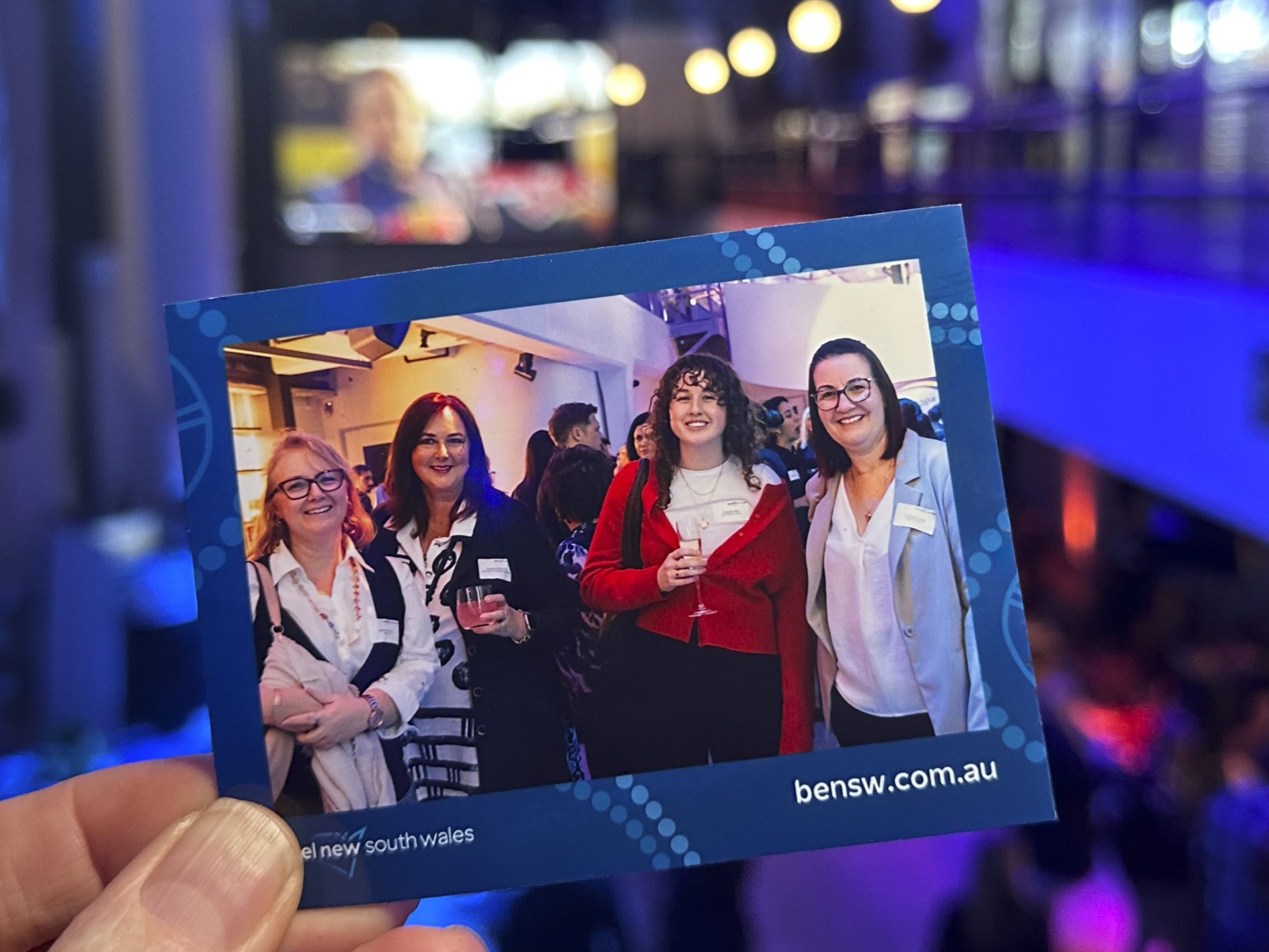 Magnetic Shots corporate event-1 holding photo magnet of 4 women at corporate networking event